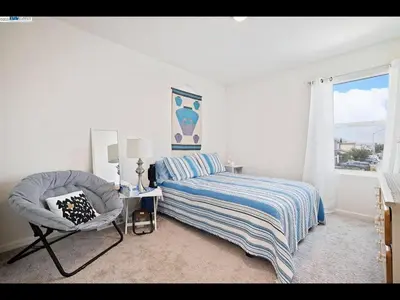a bedroom with a bed and a chair and a window at Madera lovely home in Madera