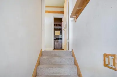 a staircase in a house with white walls and a door at Sunny Studio Ski Loft - Creekside #103 in Bear Valley