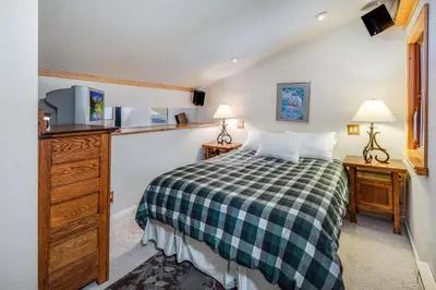 a bedroom with a green and white checkered bed at Sunny Studio Ski Loft - Creekside #103 in Bear Valley