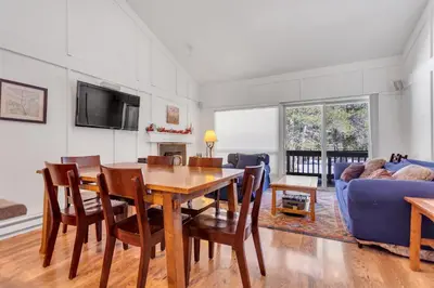 a living room with a table and a blue couch at Stylish, Remodeled Condo - Creekside #14 in Bear Valley
