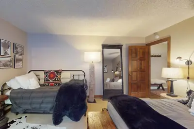 a bedroom with two beds and a mirror at The Chalet in Zephyr Cove