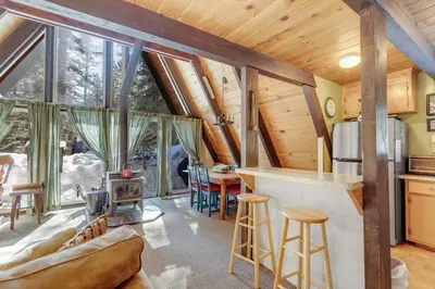a kitchen and living room in a log cabin at Popular A-frame Cabin With Deck & Views - Vh 216 in Bear Valley