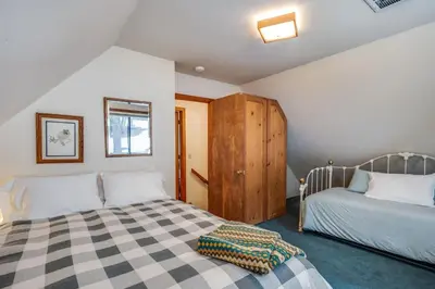 a bedroom with two beds and a wooden cabinet at Spacious Cabin Sleeps up to 12 - Sky High #86 in Bear Valley