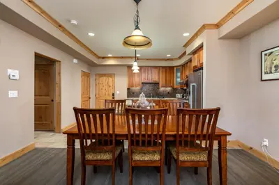 a dining room with a wooden table and chairs at Modern Condo - Jacuzzi Tub SM #201 in Bear Valley