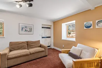 a living room with a couch and a window at Mountain Getaway with Granny Unit, Dogs Ok #47 in Bear Valley