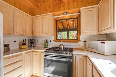 a kitchen with wooden cabinets and a stove top oven at Mountain Getaway with Granny Unit, Dogs Ok #47 in Bear Valley