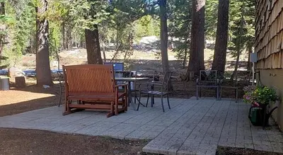a patio with a table and chairs and trees at Year Round Condo- Sleeps 5! - Tamarack #17 in Bear Valley
