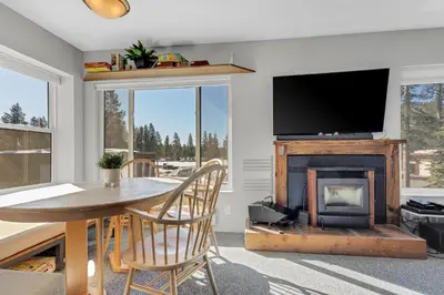 a living room with a table and a fireplace at Great Location Corner Condo - Tamarack #10 Pets Ok in Bear Valley