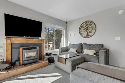 a living room with a couch and a fireplace at Great Location Corner Condo - Tamarack #10 Pets Ok in Bear Valley