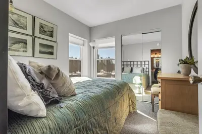 a bedroom with a bed and a desk and windows at Great Location Corner Condo - Tamarack #10 Pets Ok in Bear Valley