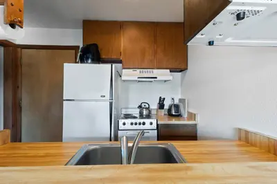 a kitchen with a sink and a white refrigerator at Comfortable Condo Great Location- Tamarack #12 in Bear Valley