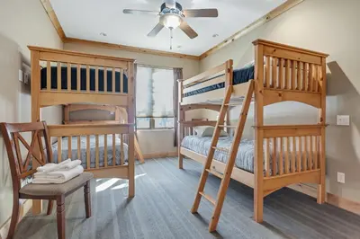 a bedroom with two bunk beds and a ceiling fan at Modern Condo - Great Location! in Bear Valley