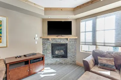 a living room with a fireplace and a flat screen tv at Modern Condo - Great Location! in Bear Valley