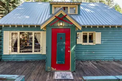 a blue house with a red door on a deck at Woodsy Wonder in Tahoe City
