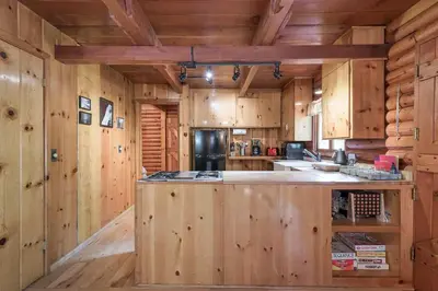 a kitchen with wooden walls and a island in a log cabin at Woodsy Wonder in Tahoe City
