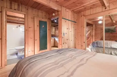 a bedroom with a bed in a room with wooden walls at Woodsy Wonder in Tahoe City