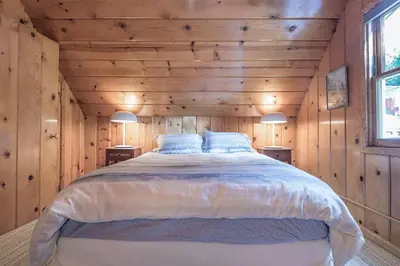 a bedroom with a large bed in a wooden wall at Woodsy Wonder in Tahoe City