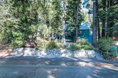 a house in the woods with a road and trees at Woodsy Wonder in Tahoe City