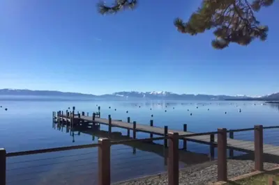 a dock on a lake with birds on the water at Woodsy Wonder in Tahoe City