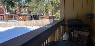 a porch with a grill on the side of a house at Modern & Sleek Condo - Creekside #110 in Bear Valley