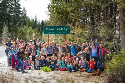 a group of people posing for a picture under a street sign at Sunny, Spacious & Pet Friendly - Creekside #39 in Bear Valley