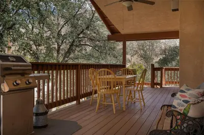 a patio with a table and chairs on a deck at Lazy Squirrel - Cozy Family House with Full Game Room in Kernville