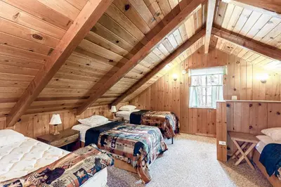 a attic room with three beds in a room at Lancaster Cabin in Bass Lake