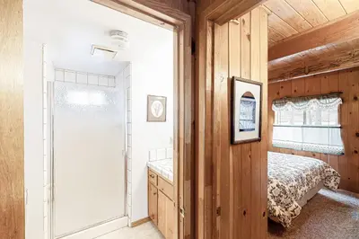 a bedroom with a bed and a sliding glass door at Lancaster Cabin in Bass Lake