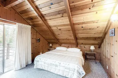 a bedroom with a large bed in a wooden ceiling at Lancaster Cabin in Bass Lake
