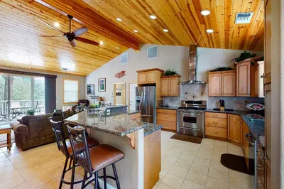 a large kitchen with wooden ceilings and a ceiling fan at Murray Lake Retreat in Bass Lake