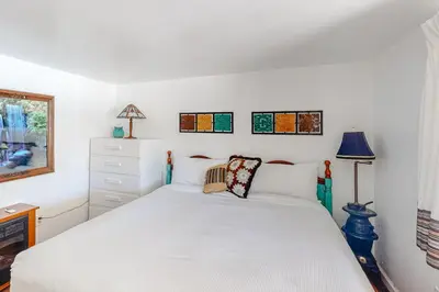 a white bedroom with a bed and a dresser at Paha Lakefront in Bass Lake