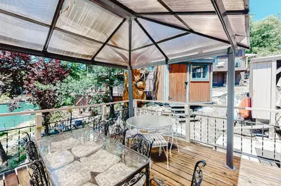 a patio with a table and chairs on a deck at Paha Lakefront in Bass Lake