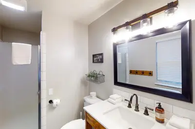 a white bathroom with a sink and a mirror at Pine Place in Oakhurst