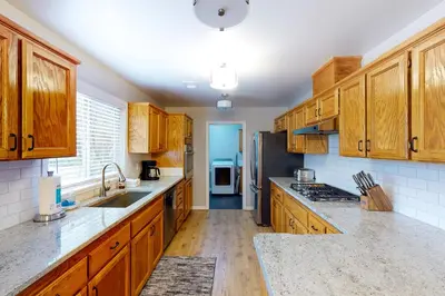 a kitchen with wooden cabinets and a sink and a refrigerator at Pine Place in Oakhurst