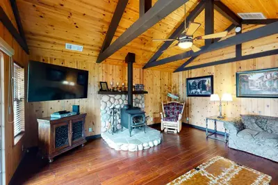 a living room with a fireplace and a couch and a tv at Calandri Lakeview House in Bass Lake