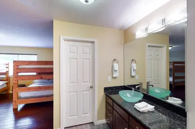 a bathroom with a sink and a mirror and a bed at Calandri Lakeview House in Bass Lake