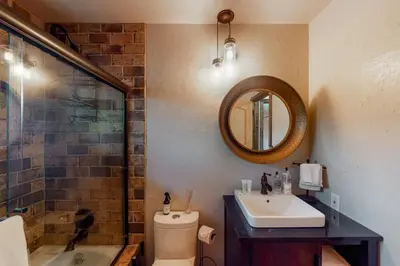a bathroom with a toilet and a sink and a mirror at Twets Lakefront in Bass Lake