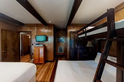 a bedroom with two bunk beds and a flat screen tv at Twets Lakefront in Bass Lake