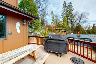 a garbage can sitting on a deck next to a bench at Alder Lake View Lodge in Bass Lake
