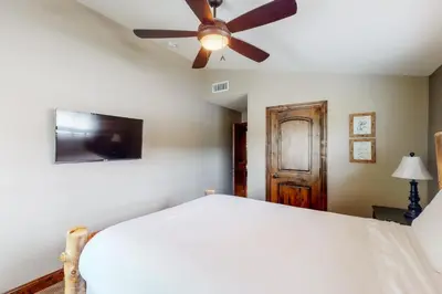 a bedroom with a ceiling fan and a bed at Brickers Lakefront in Bass Lake
