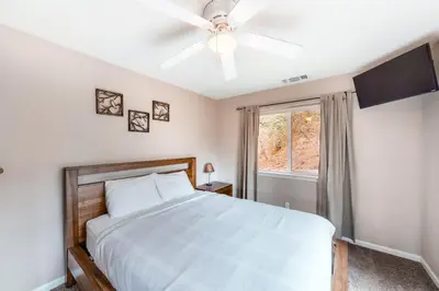 a bedroom with a bed and a ceiling fan at Robinson Shoreline House in Bass Lake