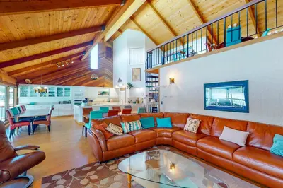a living room with a leather couch and a table at Peters Lakefront in Bass Lake
