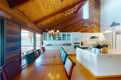 a kitchen with a wooden ceiling and a table and chairs at Peters Lakefront in Bass Lake