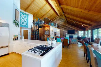 a kitchen and living room with wooden ceilings and a staircase at Peters Lakefront in Bass Lake