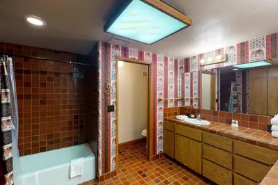 a bathroom with a tub and a sink and a mirror at Peters Lakefront in Bass Lake