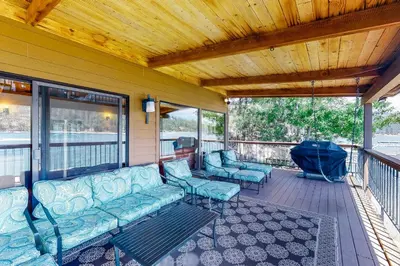 a porch with a couch and chairs on a deck at Peters Lakefront in Bass Lake