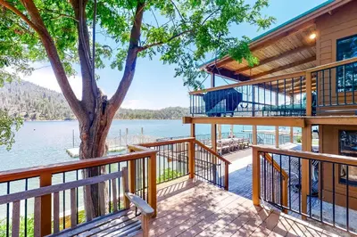 a house on the water with a tree at Peters Lakefront in Bass Lake