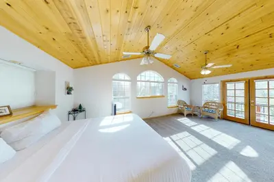 a bedroom with a white bed with a wooden ceiling at Brier Escape in Bass Lake