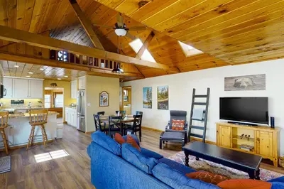 a living room with a blue couch and a kitchen at Brier Escape in Bass Lake