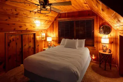 a bedroom with a large bed in a wooden room at Harris Lakeview Cabin in Bass Lake